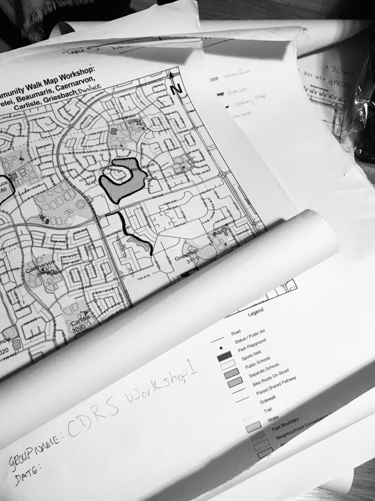 Black and white photo of maps partly unrolled.